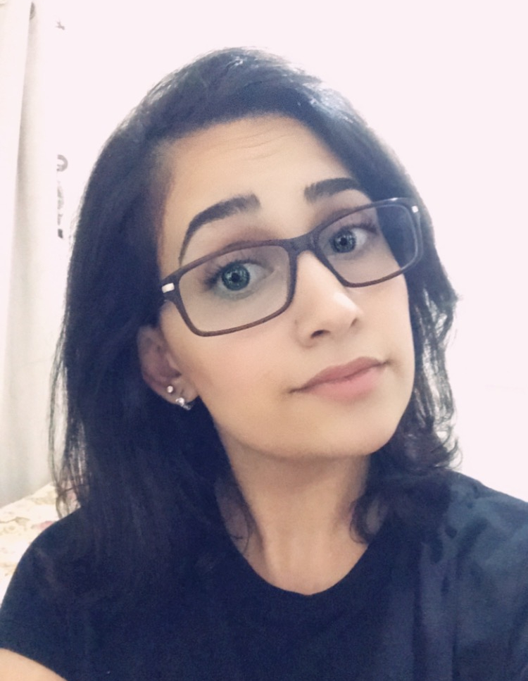 Picture of middle eastern woman with dark hair wearing glasses.