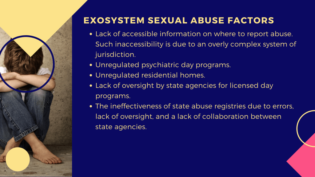 An image of a little boy setting on the floor with his arms and legs crossed, and his back to a wall. He is wearing a white t-shirt and blue jeans.