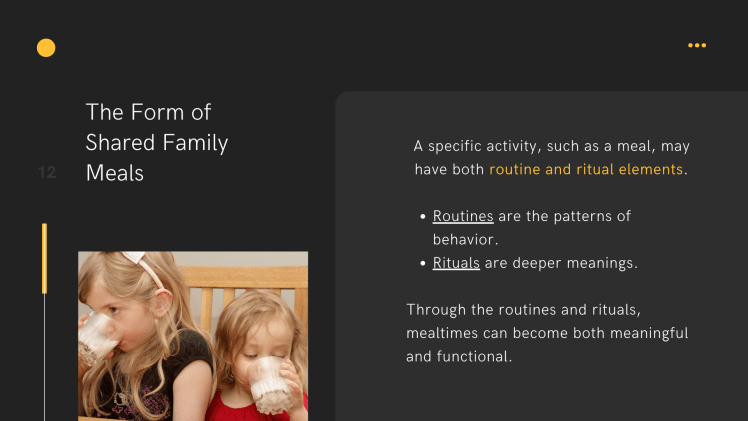 2 young girls sitting and drinking milk. One is wearing a black shirt and the other is wearing a red shirt.